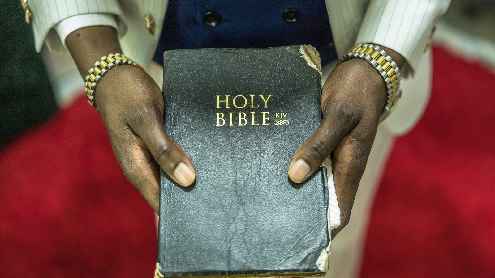 A photograph showing a close image of hands holding a bible.