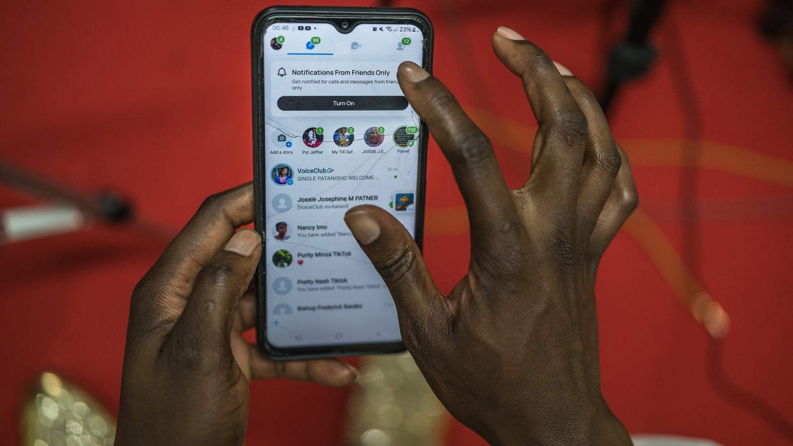 A close photograph of hands using a social platform on a mobile phone.
