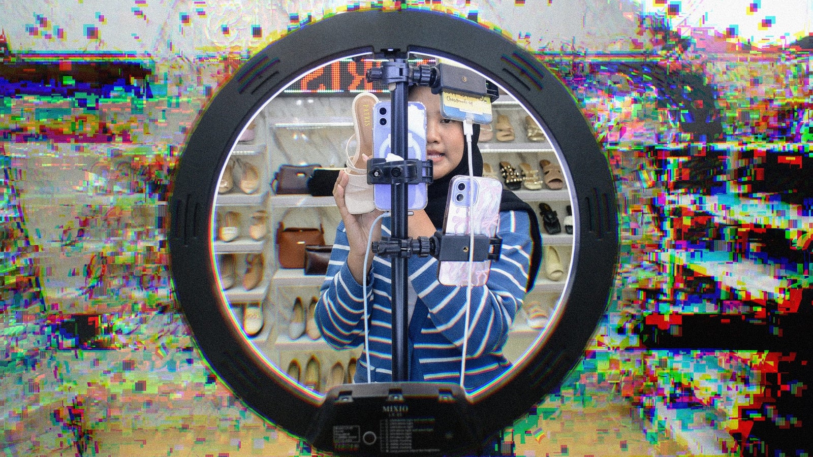 A person wearing a striped shirt and a hijab is holding a phone in front of a ring light, with shelves of shoes and bags visible in the background. The image has a distorted, glitch effect.