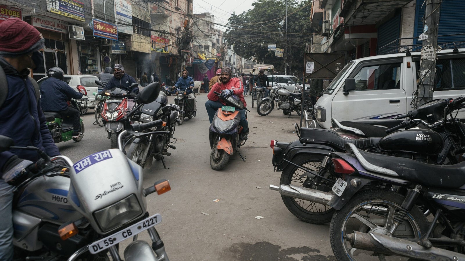 Mannu Kumar, Zomato’s delivery partner speaks on his phone while parked on a busy street.