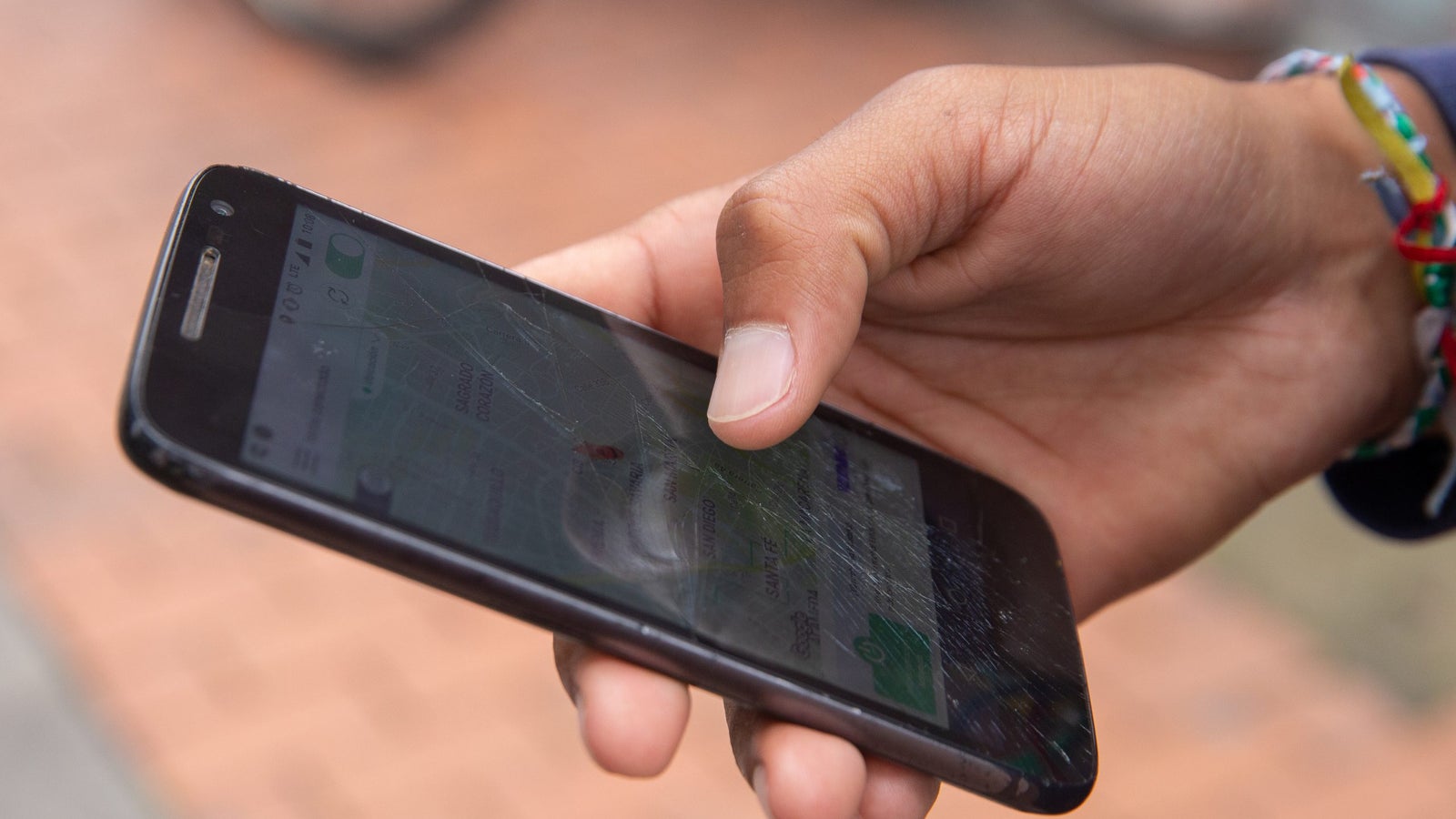 A close-up photo of a hand using a touchscreen phone.