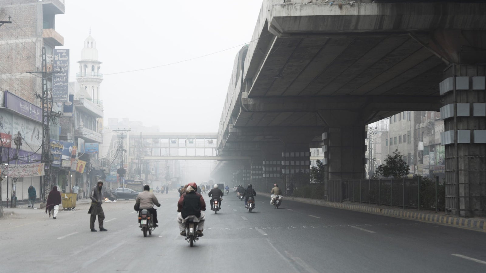 A road beneath an overpass in Lahore, Pakistan with heavy smog.