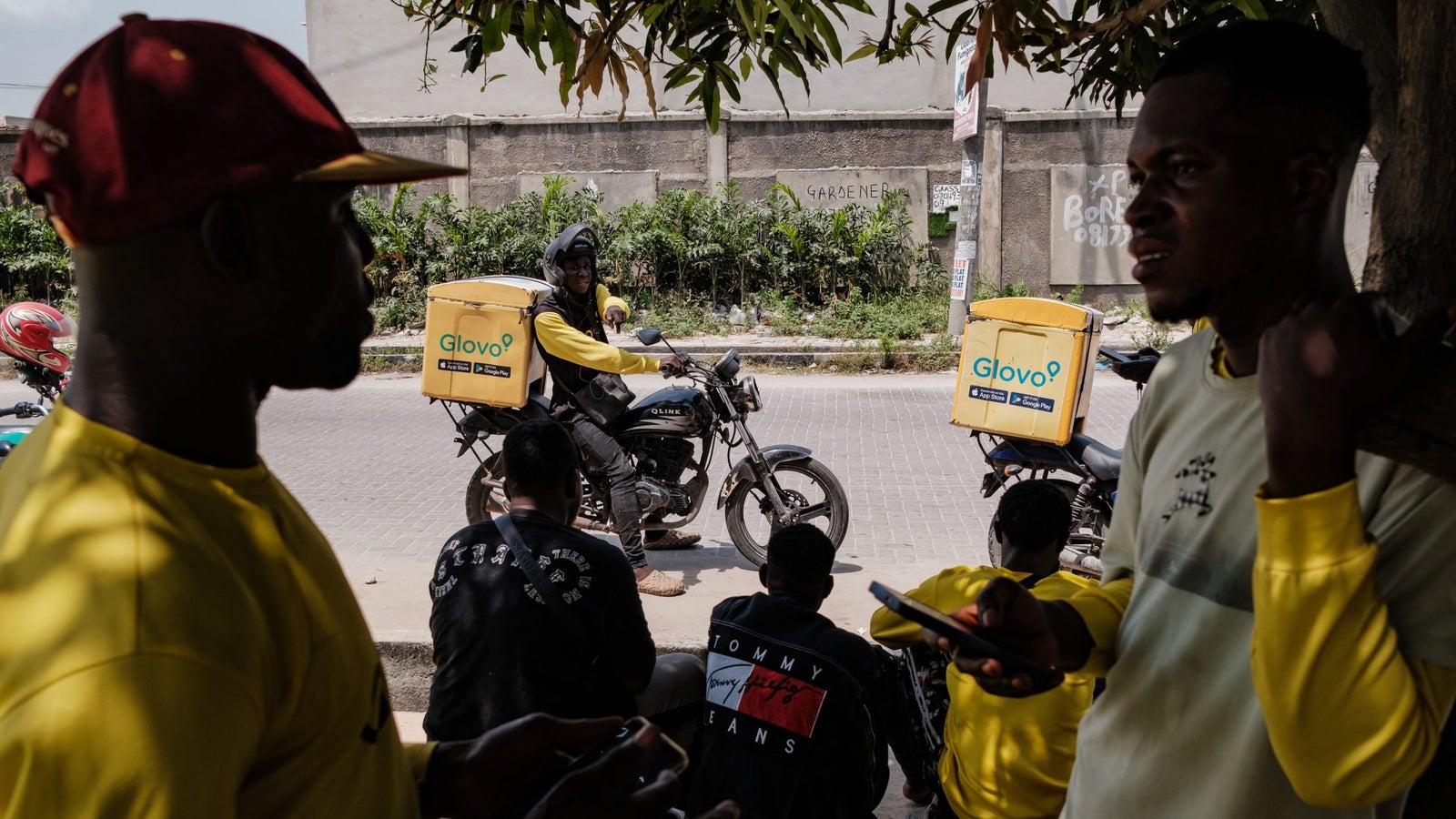 Gig workers gather under a tree in lekki, a popular resting point in the area.