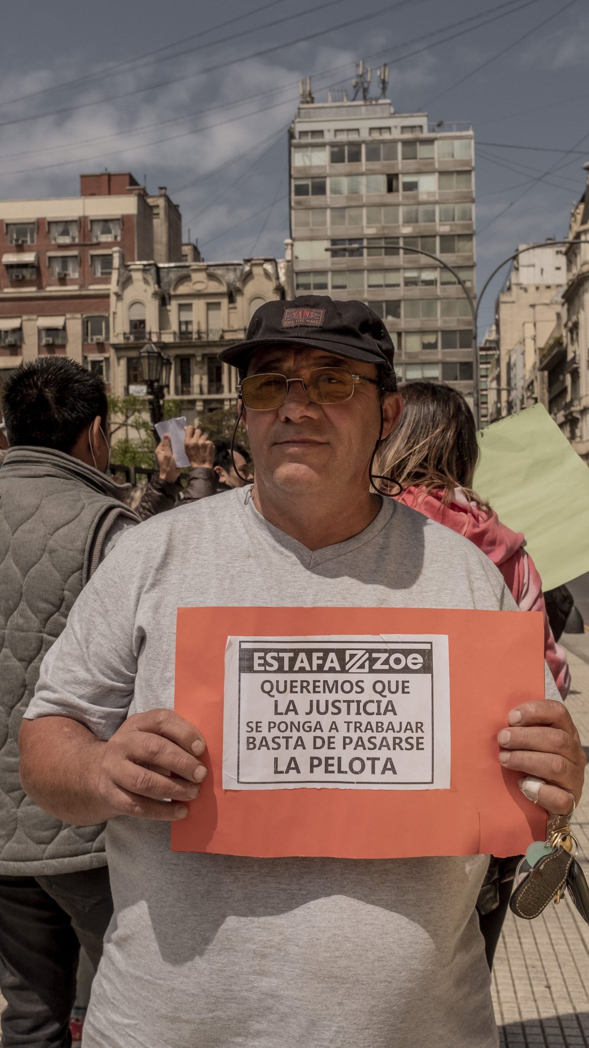 A photo of a man holding a sign at a protest against Generation Zoe in Argentina.