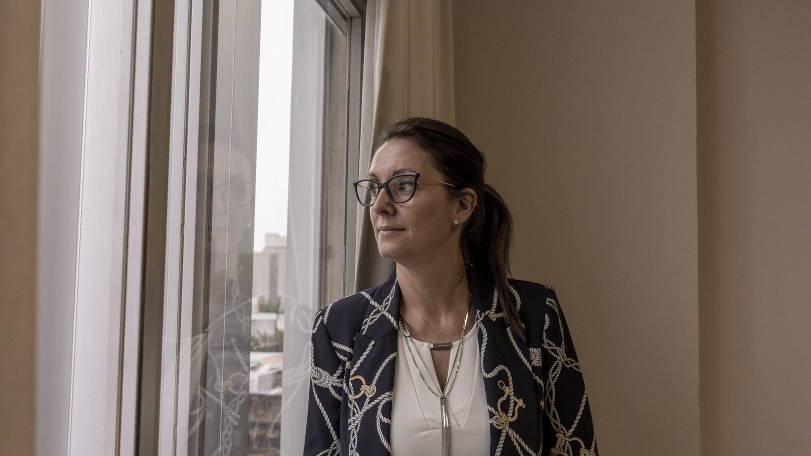 A photo of prosecutor Juliana Company looking looking out a window in her office in Argentina.