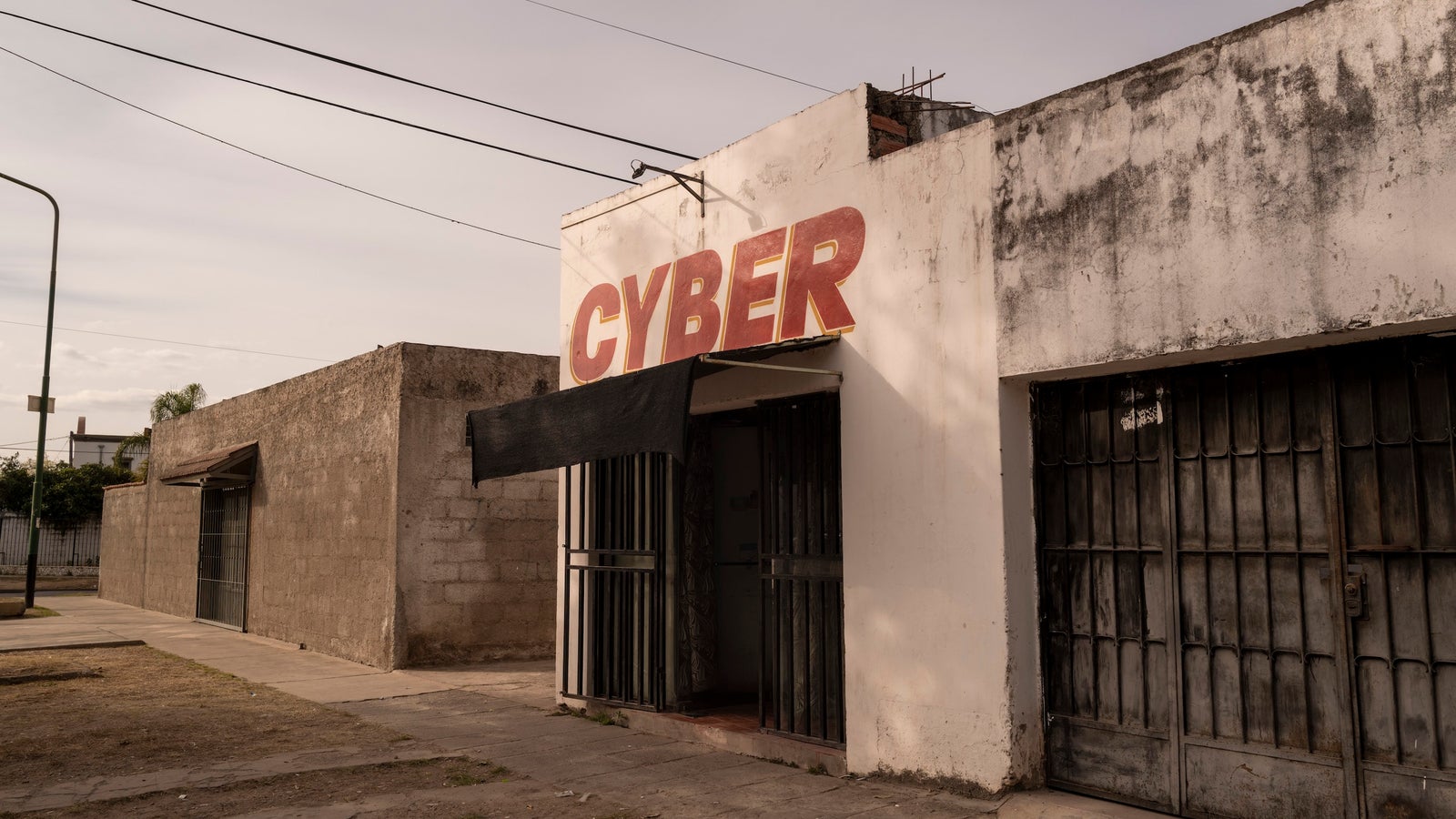 A photo of a plain, white concrete building with the word Cyber on the top in red.