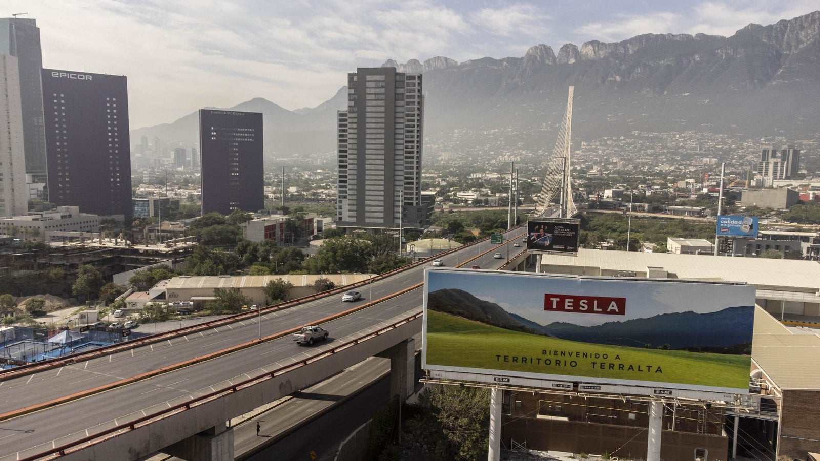 A drone photo showing a billboard and the skyline of Monterrey, Mexico.