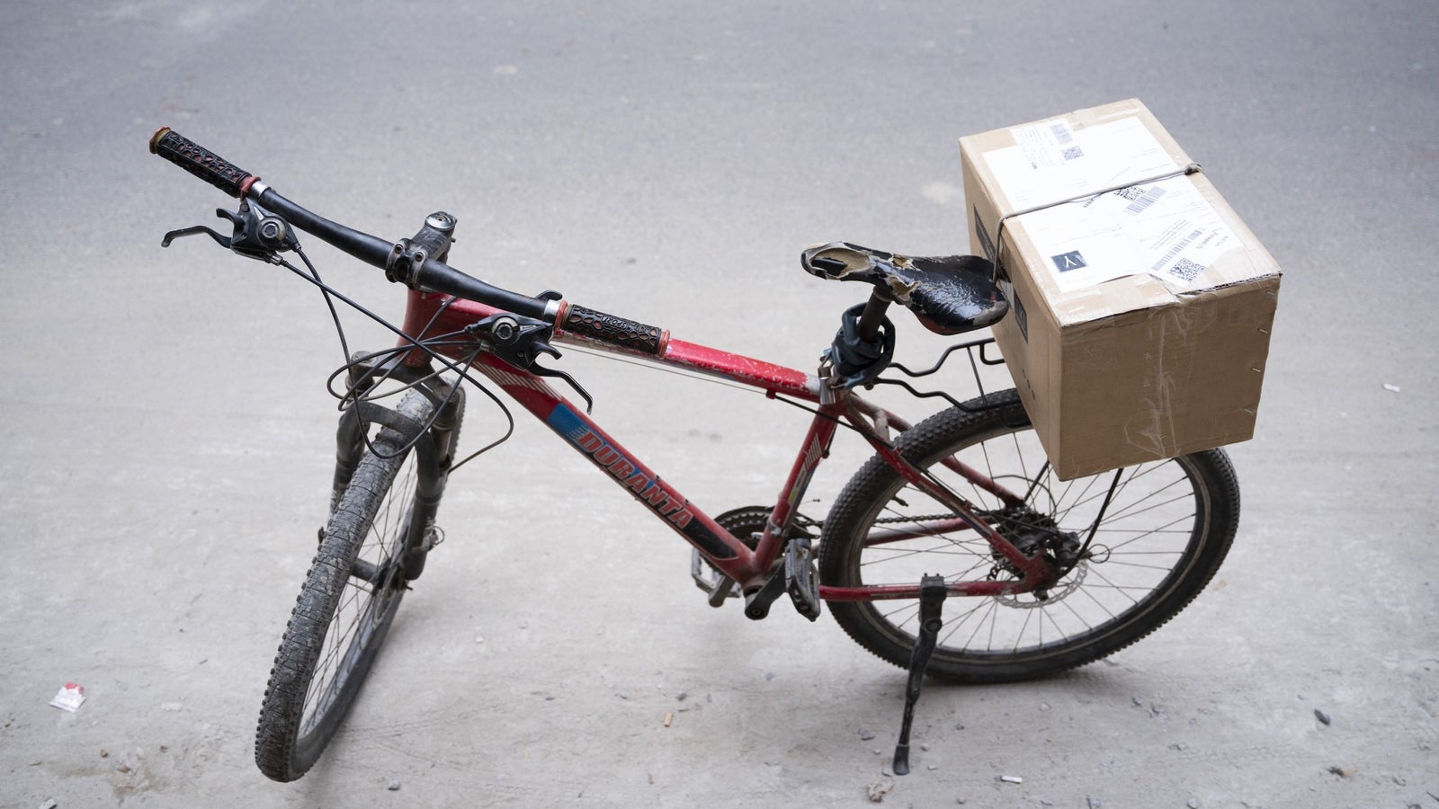 A bicycle with a delivery box attached to the rear.