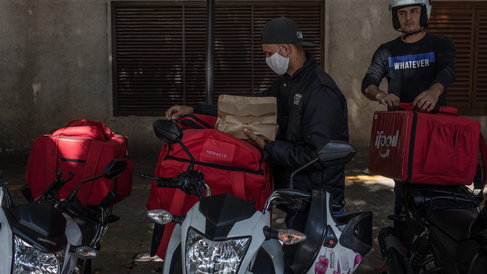 Workers place food in iFood insulated delivery bags in Sao Paulo, Brazil.