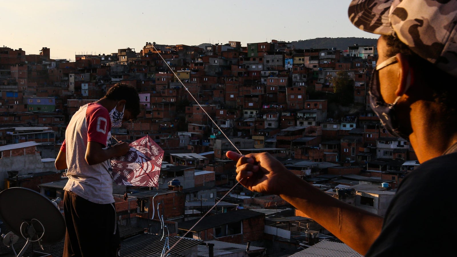 Boys wearing face masks fly kites over the city in Sao Paulo, Brazil.