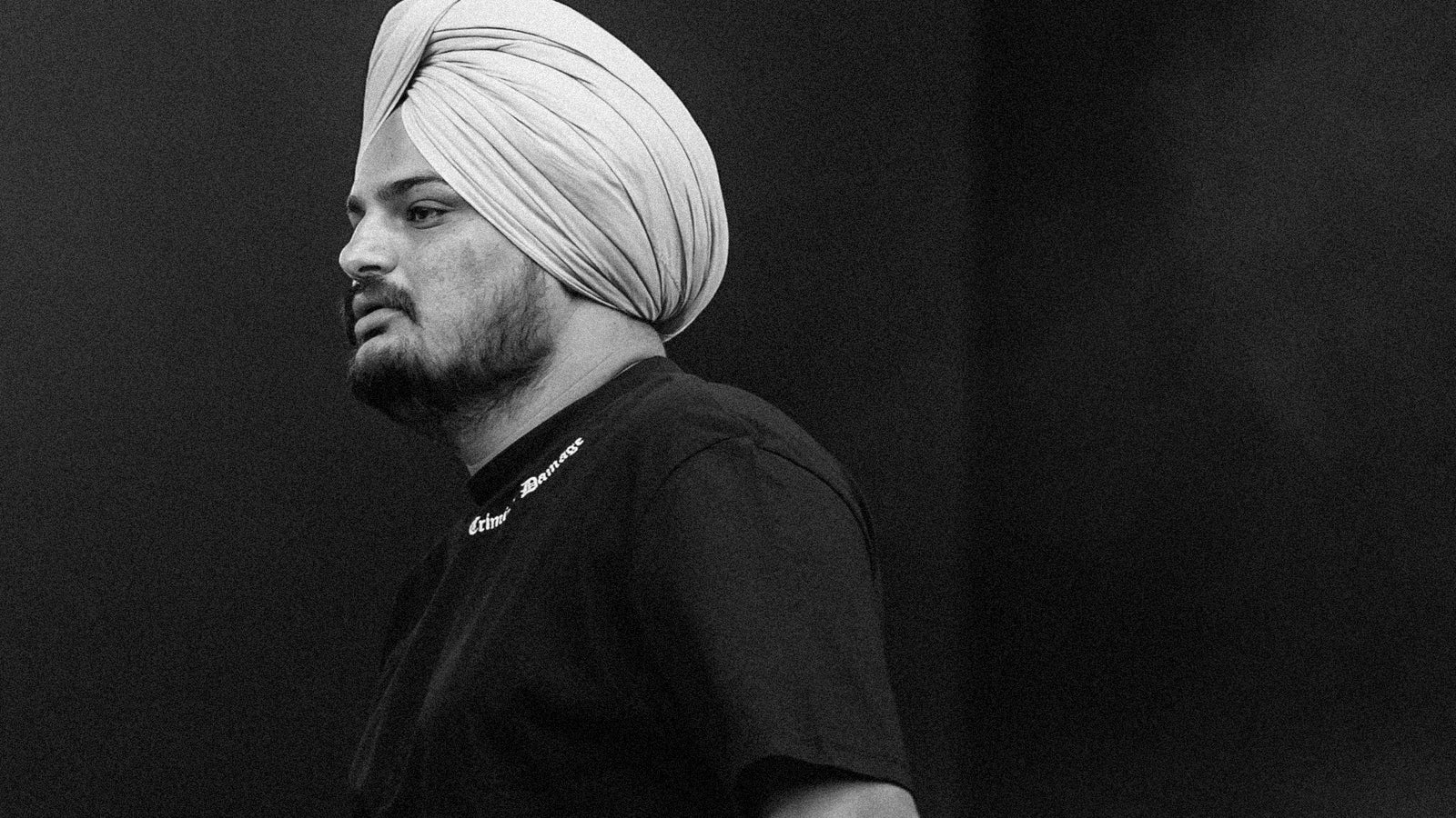 This photo shows side profile of Punjabi rapper Sidhu Moosewala in monochrome.