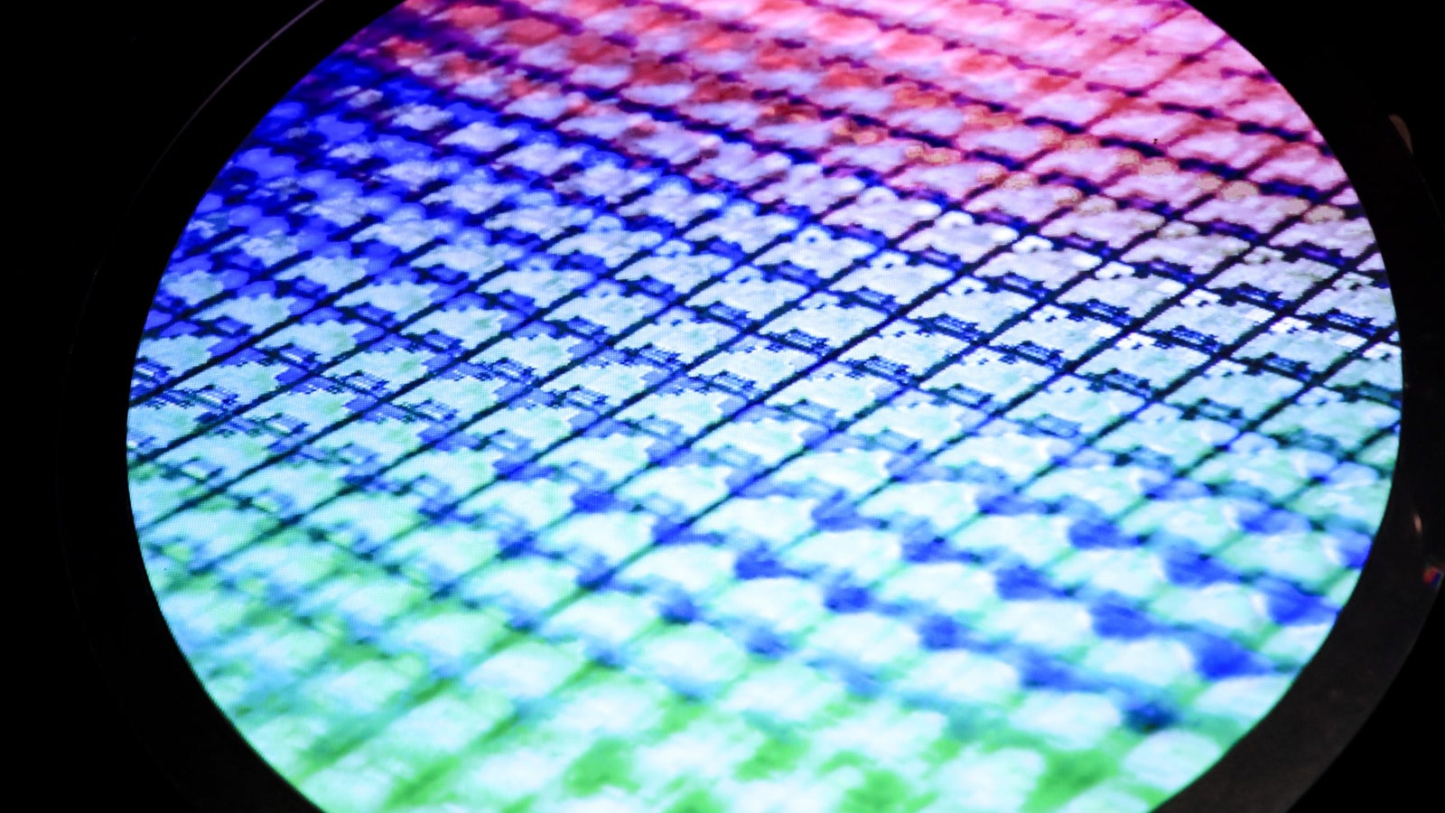 A detailed photograph of a colorful semiconductor wafer.