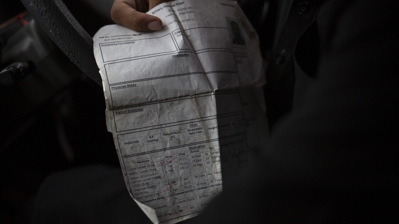 A hand holding a document with diabetic medical information.