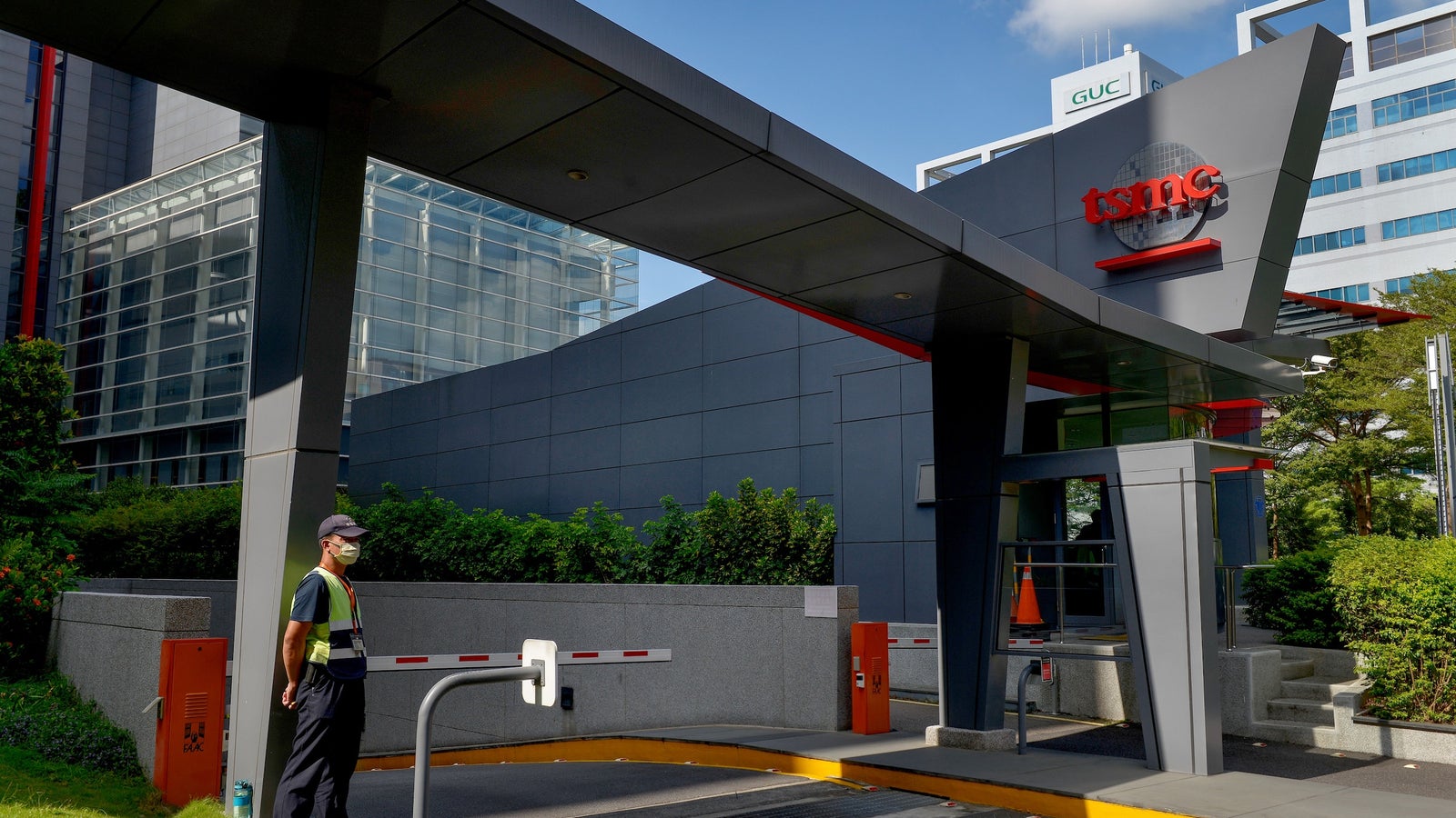 A photograph showing the entrance to the TSMC headquarters in Taiwan with a guard standing at attention.