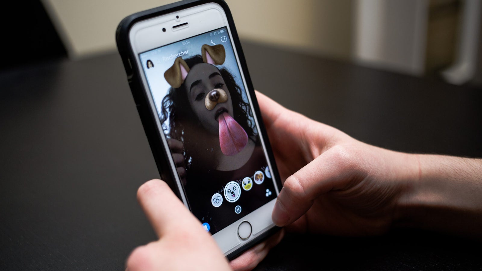 A close-up photo of a phone showing the dog filter on Snapchat