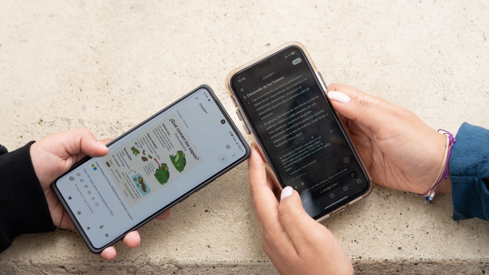 Two people are holding smartphones side by side. The left phone displays a colorful infographic about frogs in Spanish, while the right phone shows a dark mode web page with text on frog development. Both phones are resting on a light-colored surface.