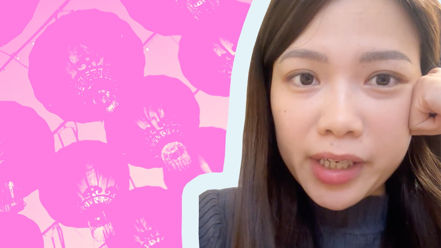 A young woman with long black hair is speaking, with a background of pink flowers and lanterns.