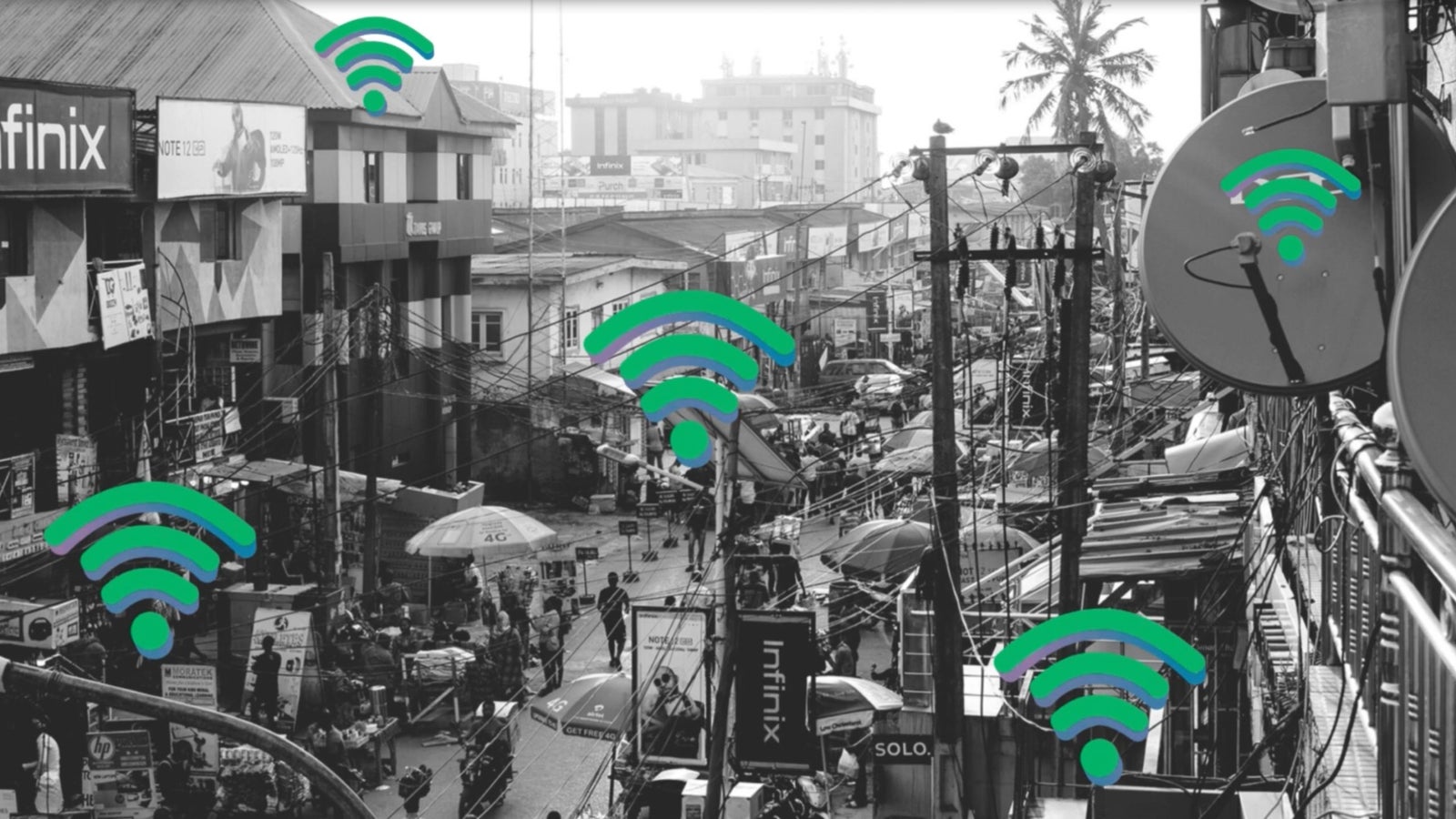 A bustling street scene in black and white, showcasing a crowded market with people and vendors, surrounded by buildings and power lines, overlayed with multiple colorful Wi-Fi symbols indicating connectivity.