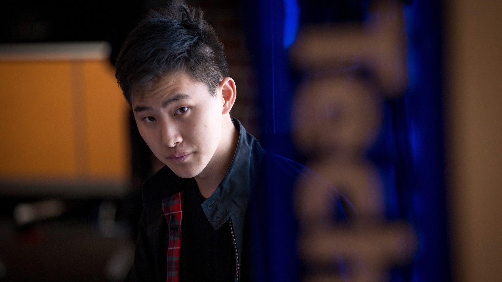 A photo of Alexandr Wang looking at the camera with a bit of lens blur on the right hand side of the screen.