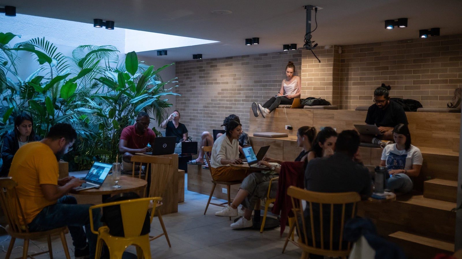 A photo showing a crowded co-working space in Colombia, with lots of people working on laptops.