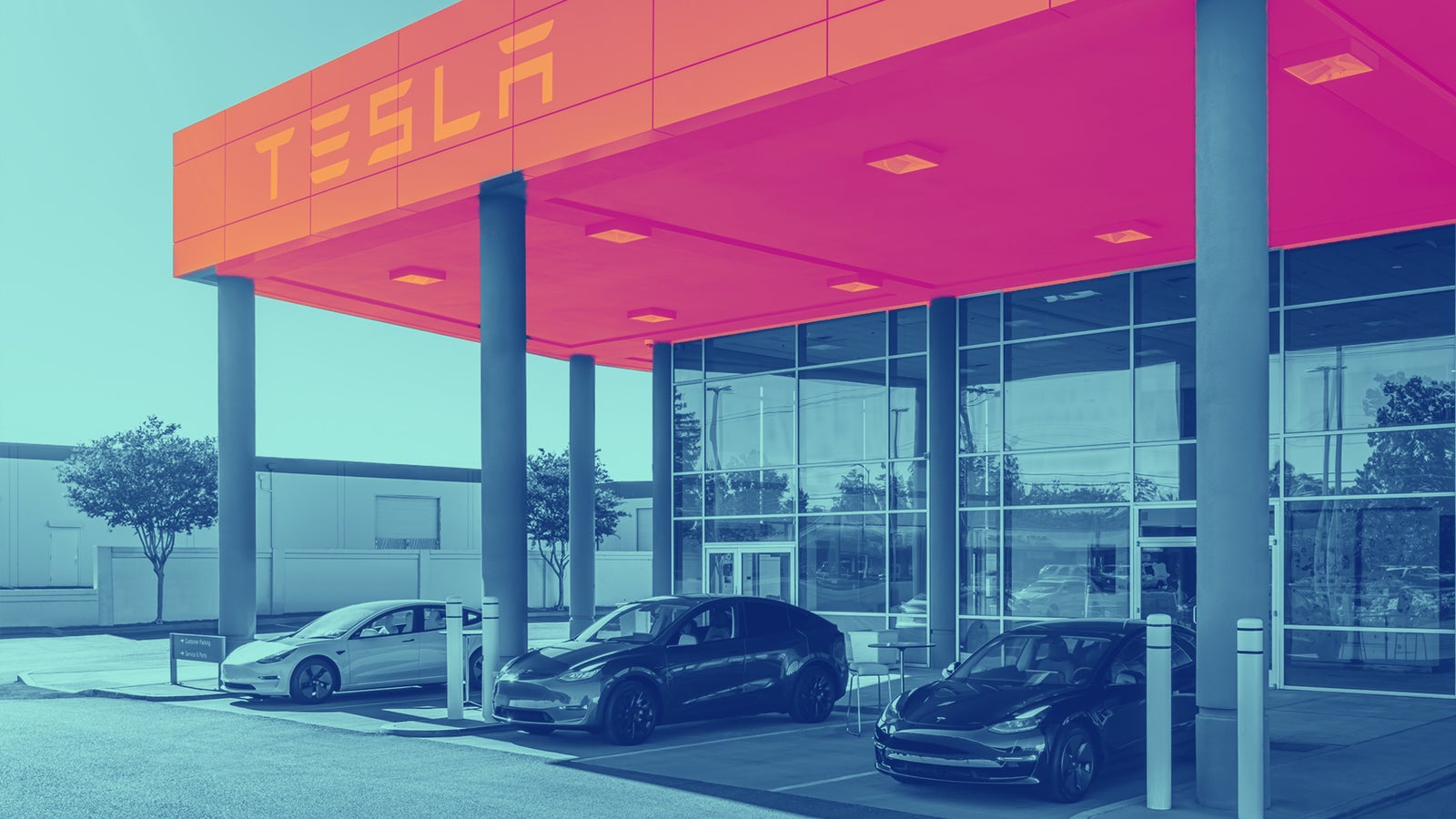 A Tesla showroom featuring three models parked outside under bright signage and a modern, colorful facade.