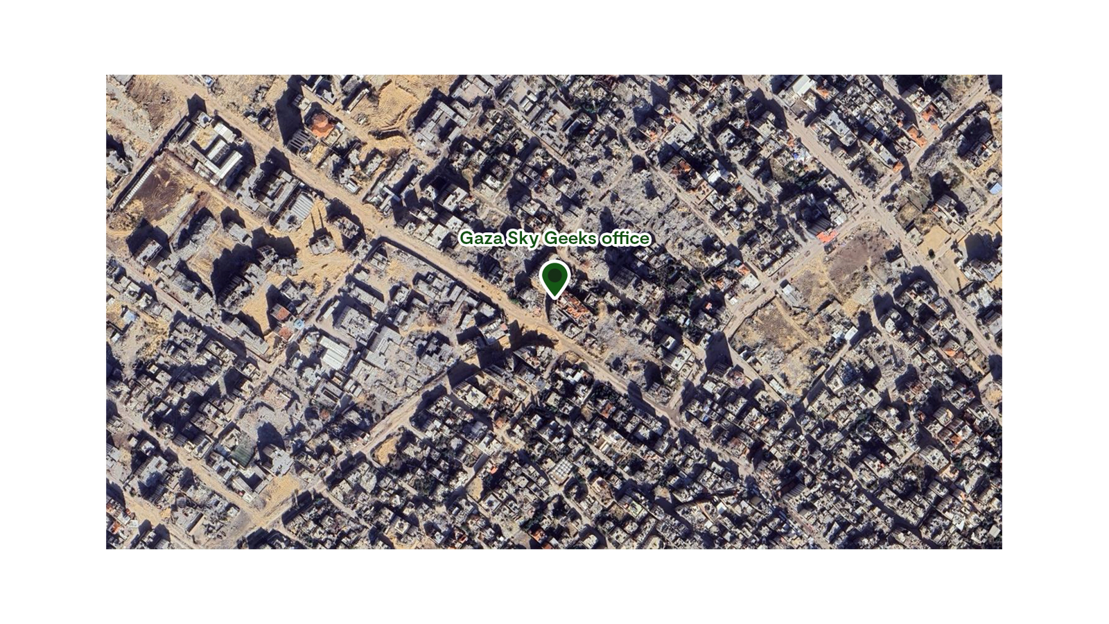 Aerial view of a densely built area with a marker indicating the location of the Gaza Sky Geeks office.
